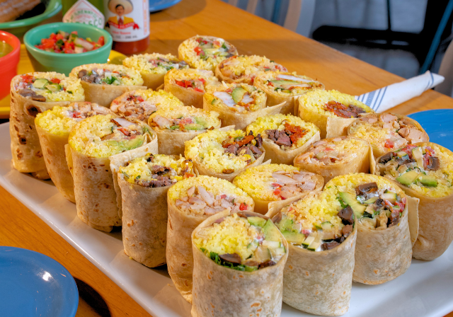 Burritos, halved, on a platter