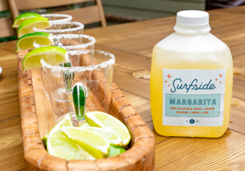 Jug of 32oz margarita with cactus cups and limes